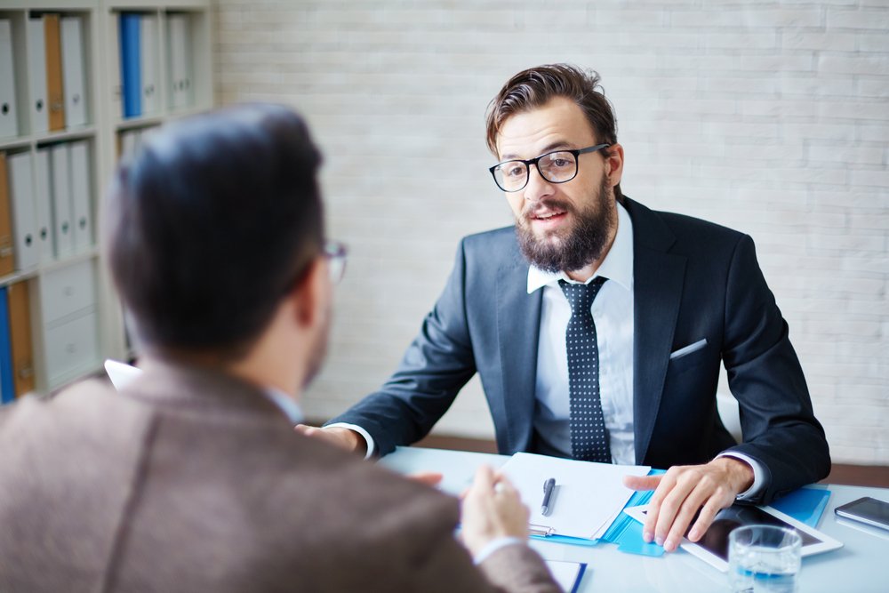 A boss talking to an employee in the office. | Photo: Shutterstock.