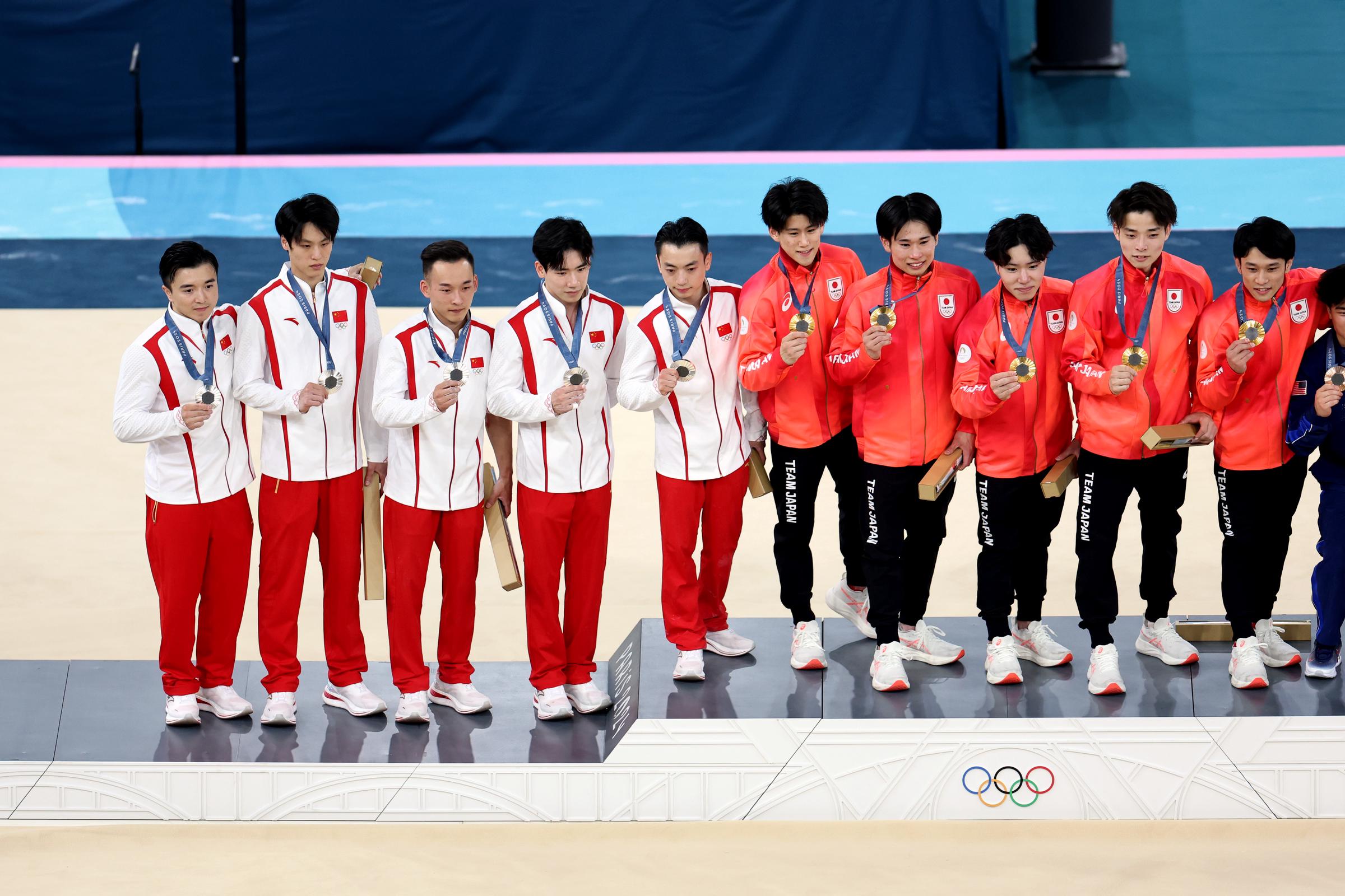 Silver medalists Liu Yang, Su Wei, Xiao Ruoteng, Zhang Boheng, and Zou Jingyuan of Team China and gold medalists Daiki Hashimoto, Kazuma Kaya, Shinnosuke Oka, Takaaki Sugino, and Wataru Tanigawa of Team Japan pose on the podium at the Paris 2024 Olympics on July 29, 2024 | Source: Getty Images