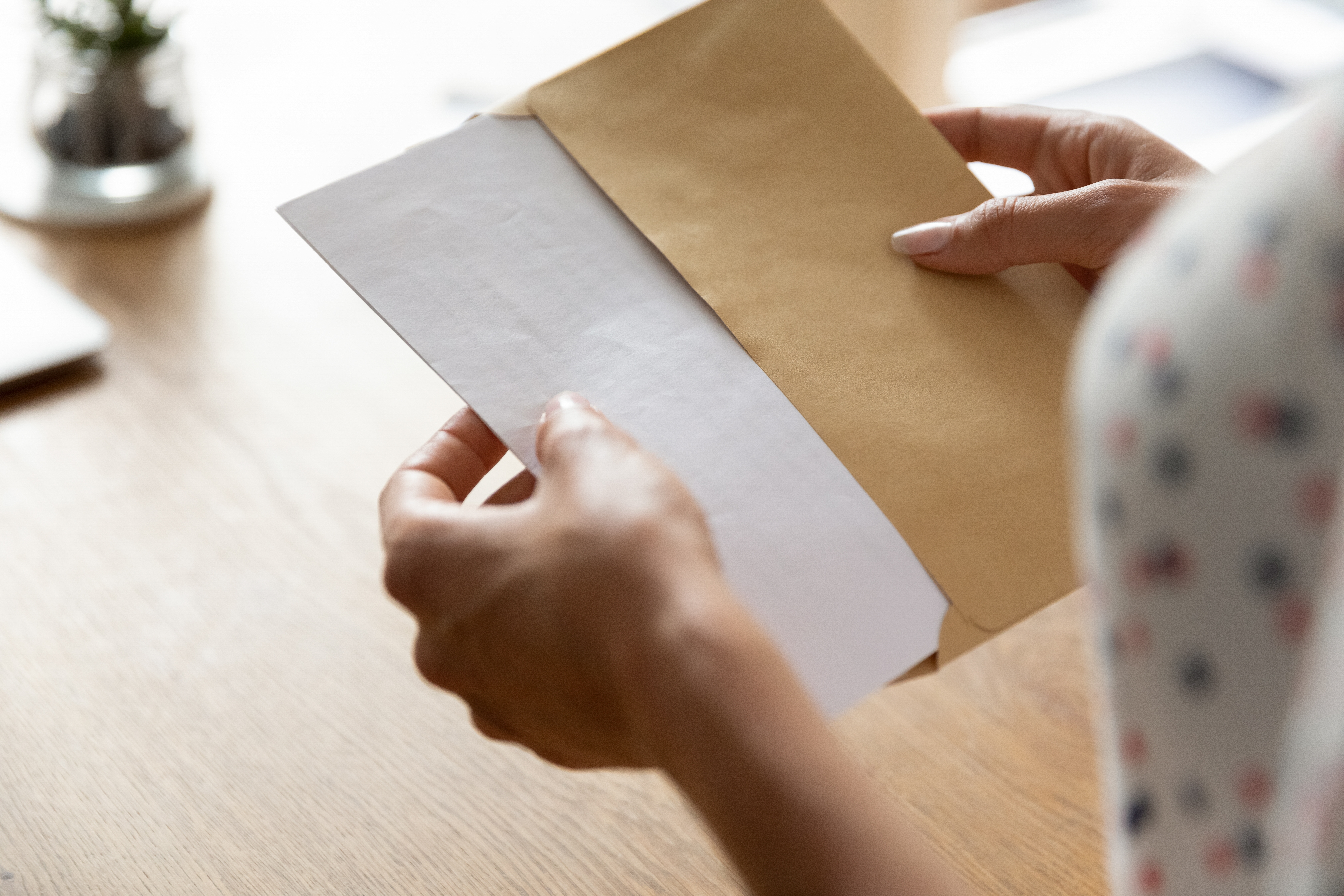 Hands of woman receiving letter | Source: Shutterstock