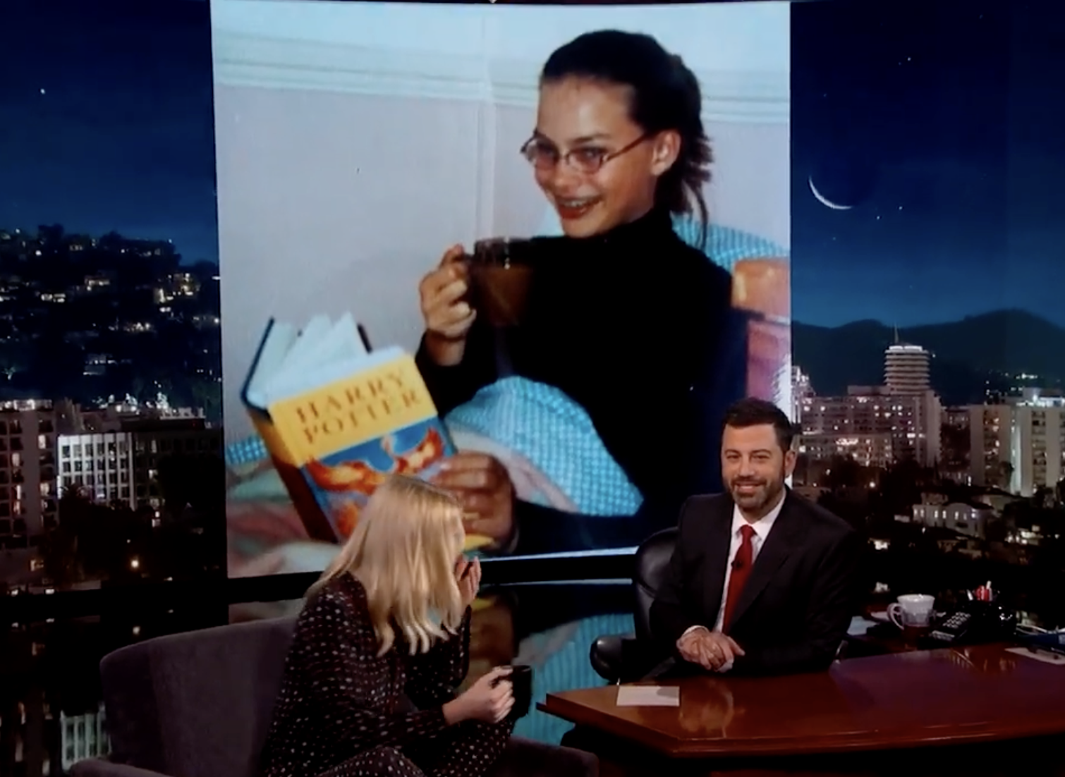 Margot Robbie was raised by a single mother. In this picture, she is showing Jimmy Kimmel a picture from her childhood on June 29, 2016 | Source: YouTube/Jimmy Kimmel Live