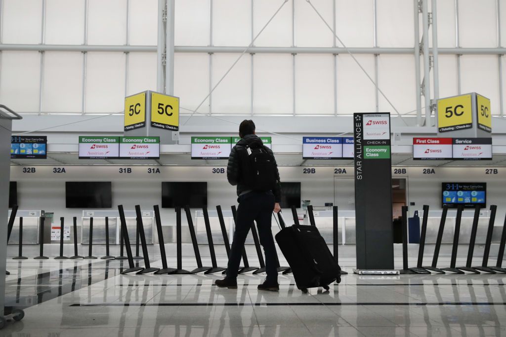 A person in the airport, carrying luggage. | Source: Getty Images