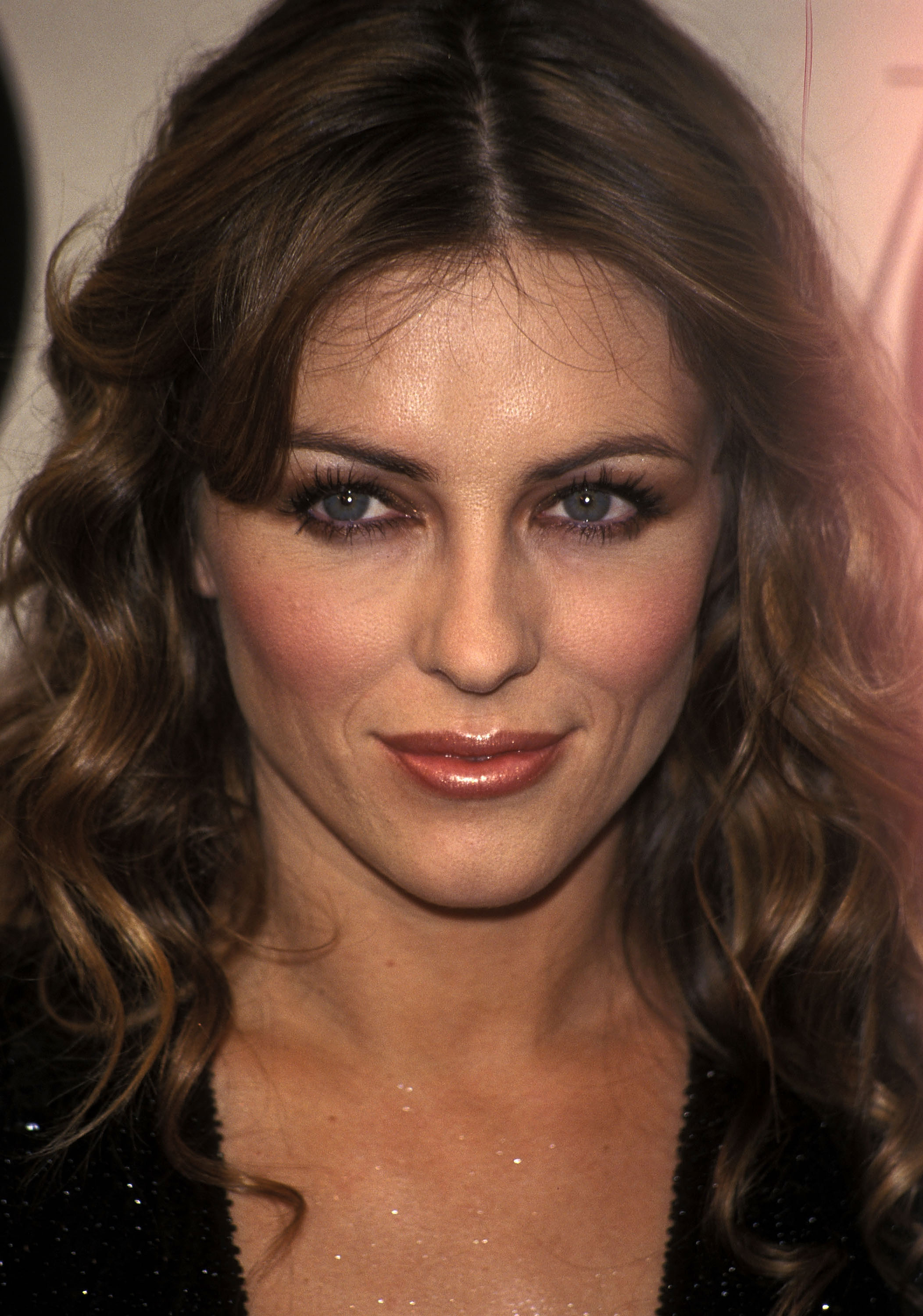 A close-up of Elizabeth Hurley at the 2000 Vogue Fashion Awards in New York, her highlighted brunette waves framing her face and striking blue eyes — the same bone structure fans would later clock on her son.