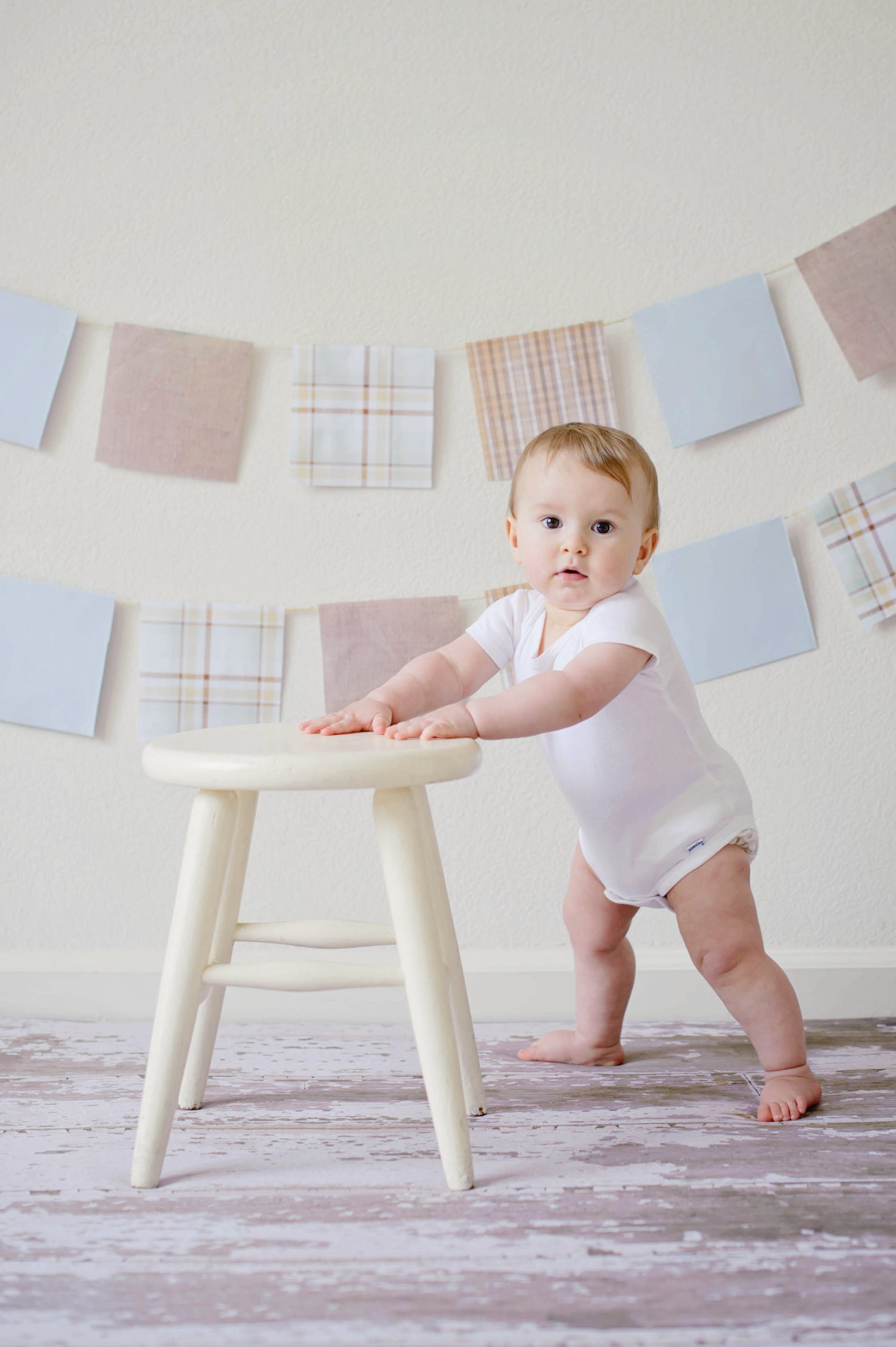 A baby holding a stool | Source: Pexels