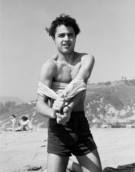 Sal Mineo se quita la camisa en la playa en 1956, en Santa Mónica, California. | Imagen: Getty Images