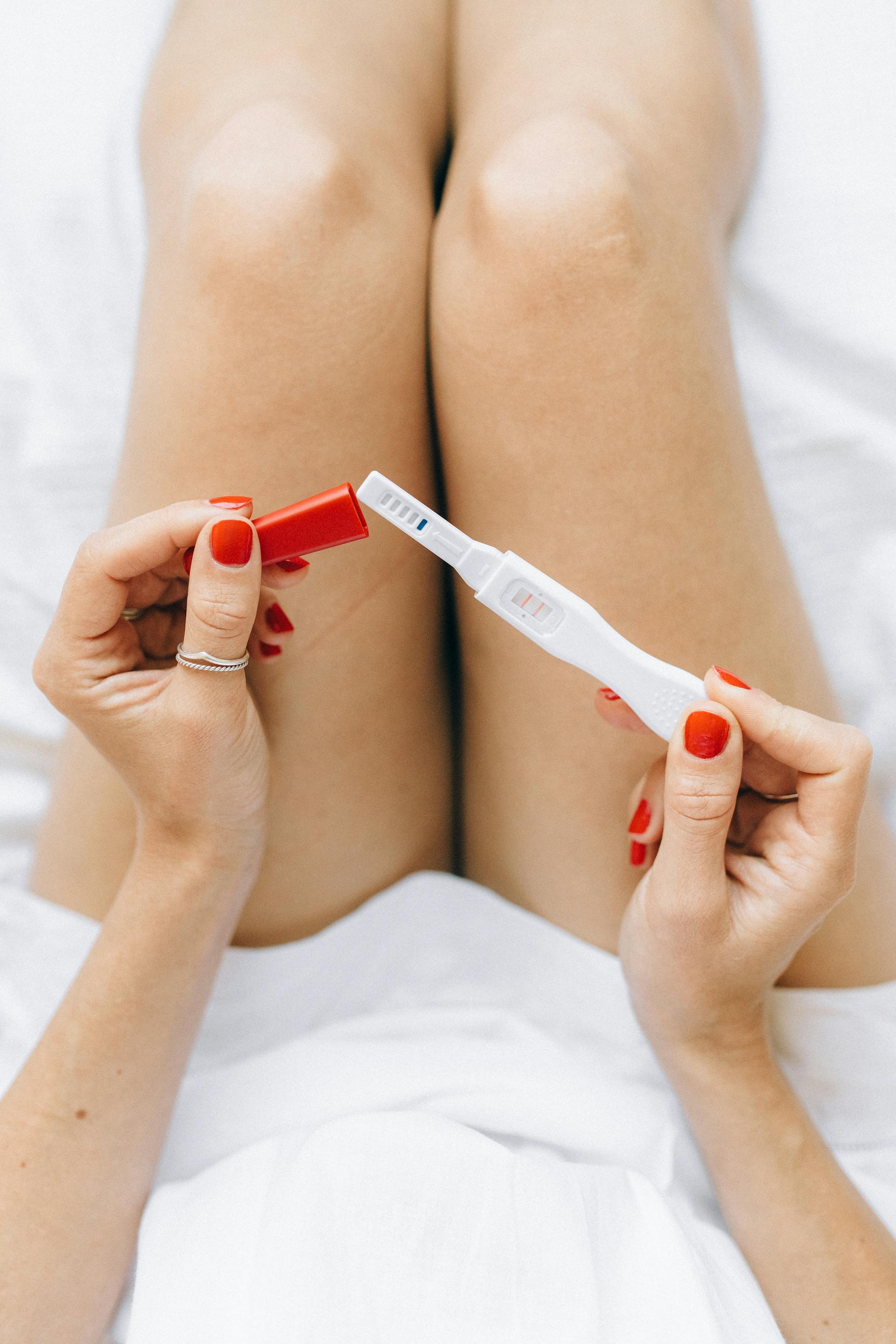 A woman holding a pregnancy test kit | Source: Pexels