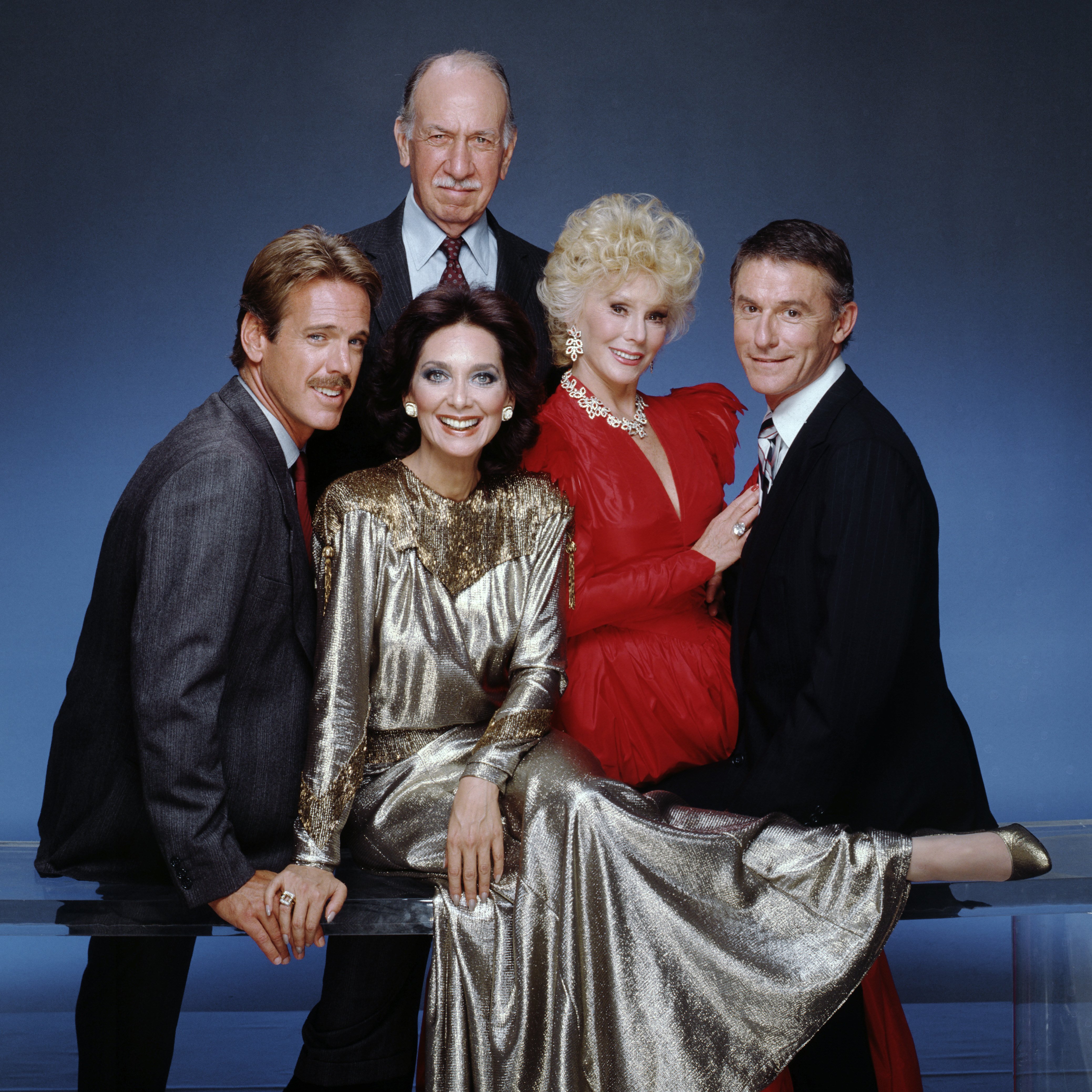 Eva Gabor (in red) along with the stars of the 1986 TV series "Bridges To Cross." | Photo: Getty Images