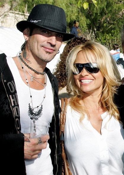 Musician Tommy Lee and actress Pamela Anderson pose at the home of John Paul DeJoria, CEO and co-founder of John Paul Mitchell Haircare Systems, during his annual party to thank movie, television and music star friends and his co-workers for their charitable work on December 24, 2005, in Malibu, California. | Source: Getty Images