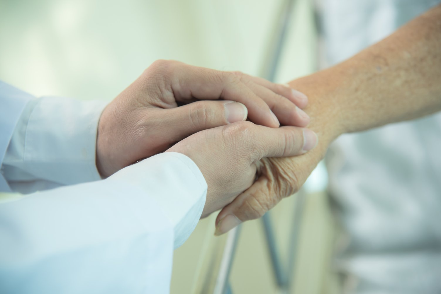 Holding elderly patient's hand. | Photo: Shutterstock
