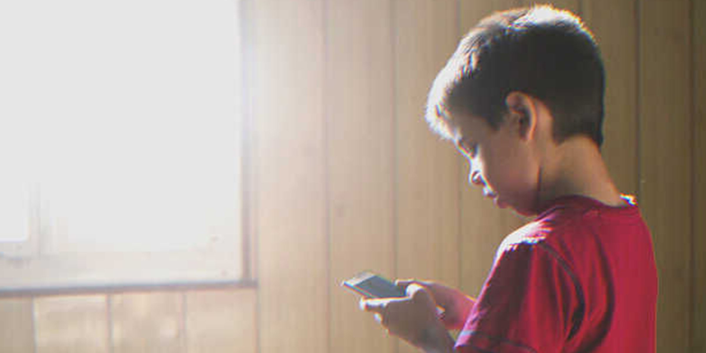 Boy using a smartphone | Source: Shutterstock