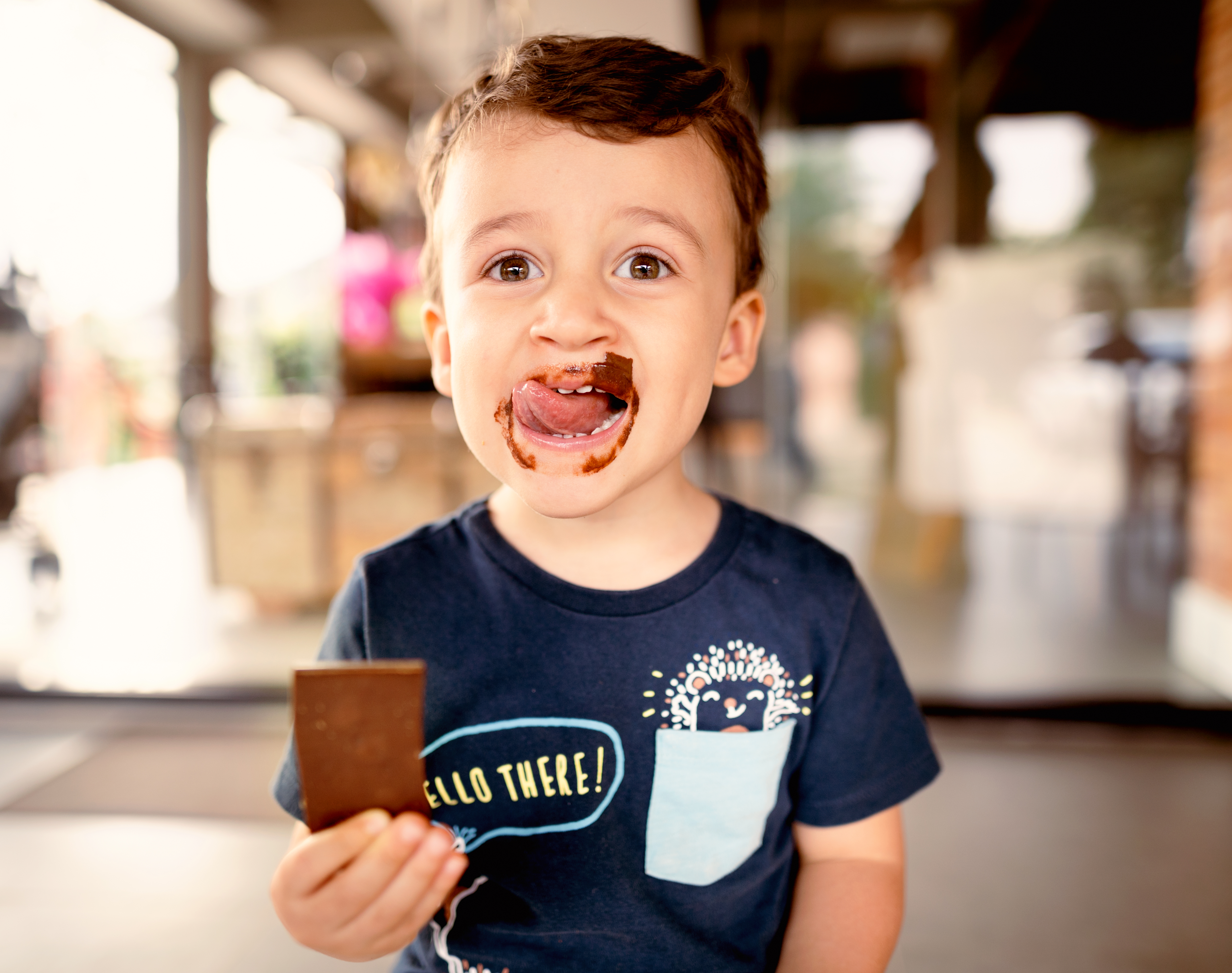 Smiling little boy licking messy chocolate from his face | Source: Getty Images