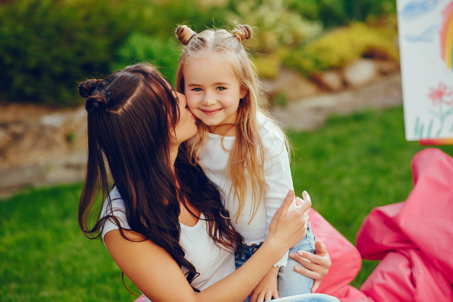 A woman kissing her daughter on the cheek | Source: Freepik