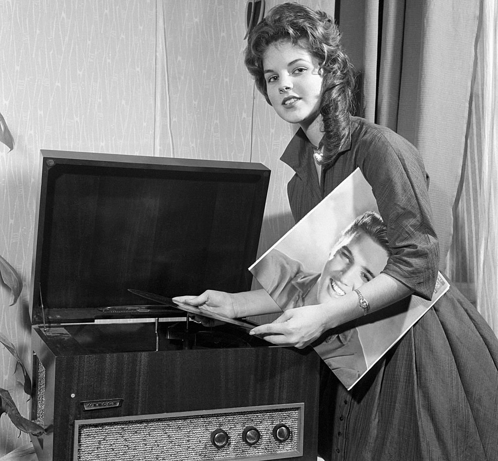Priscilla Beaulieu plays a record album by teen idol, Elvis Presley's | Source: Getty Images 