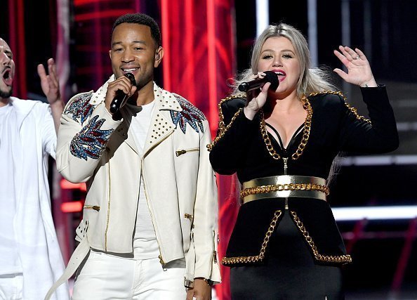 John Legend (L) and host Kelly Clarkson speak onstage during the Billboard Music Awards on May 20, 2018 in Las Vegas, Nevada | Photo: Getty Images