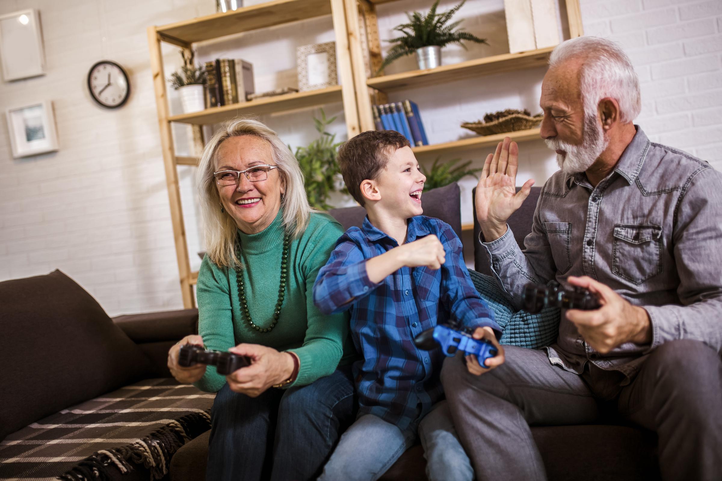 An older couple enjoying a video game with a young boy | Source: Shutterstock