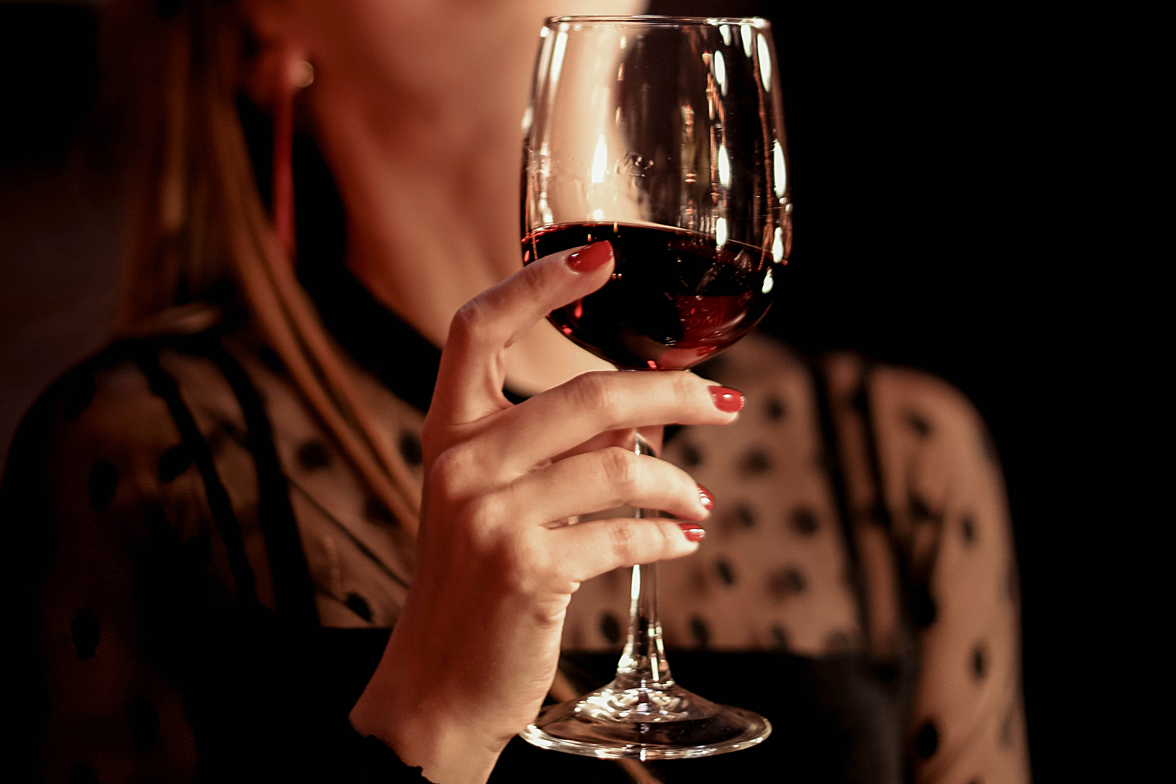 Female hand holding glass of red wine | Source: Shutterstock