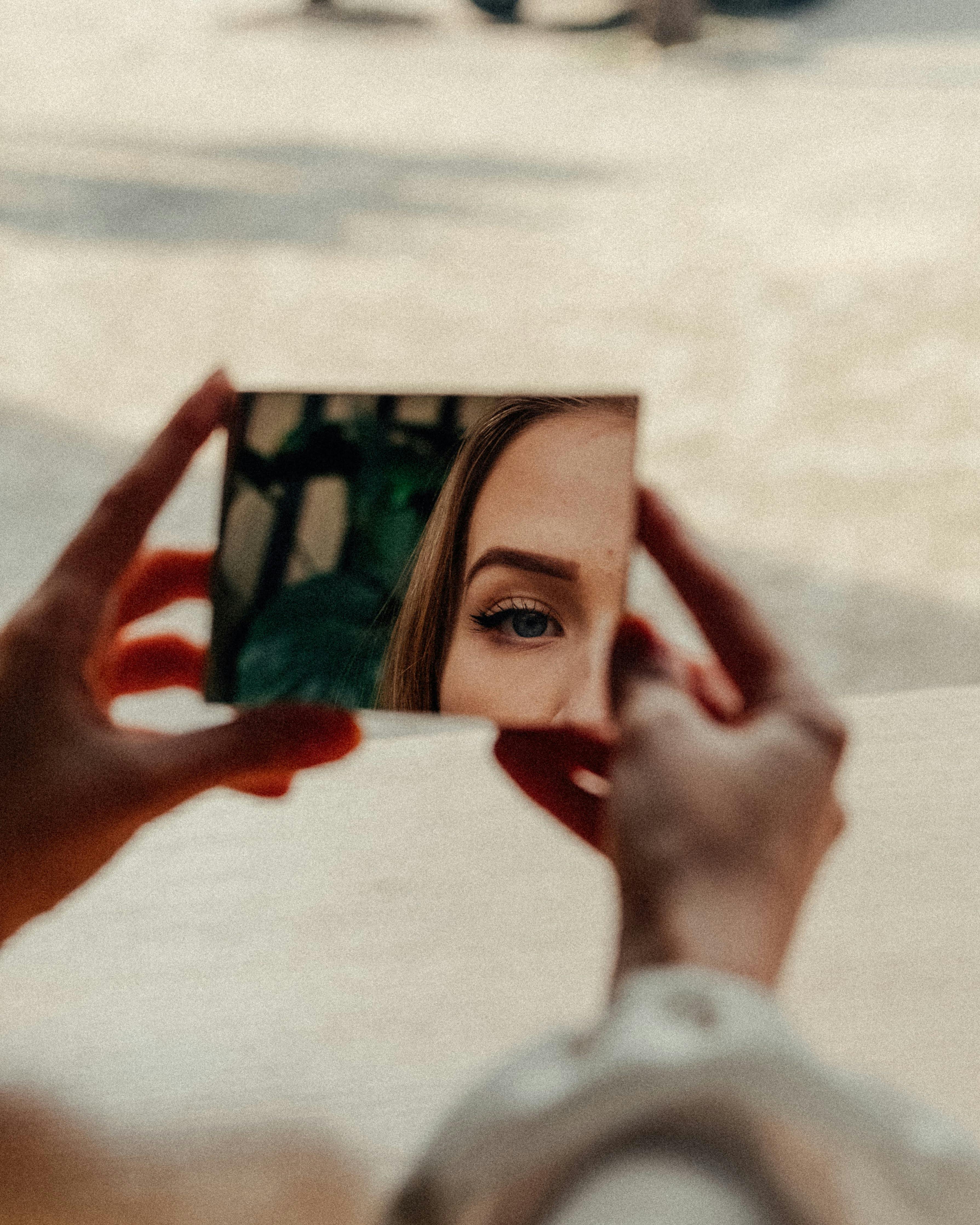 A woman checking her reflection in the mirror | Source: Pexels