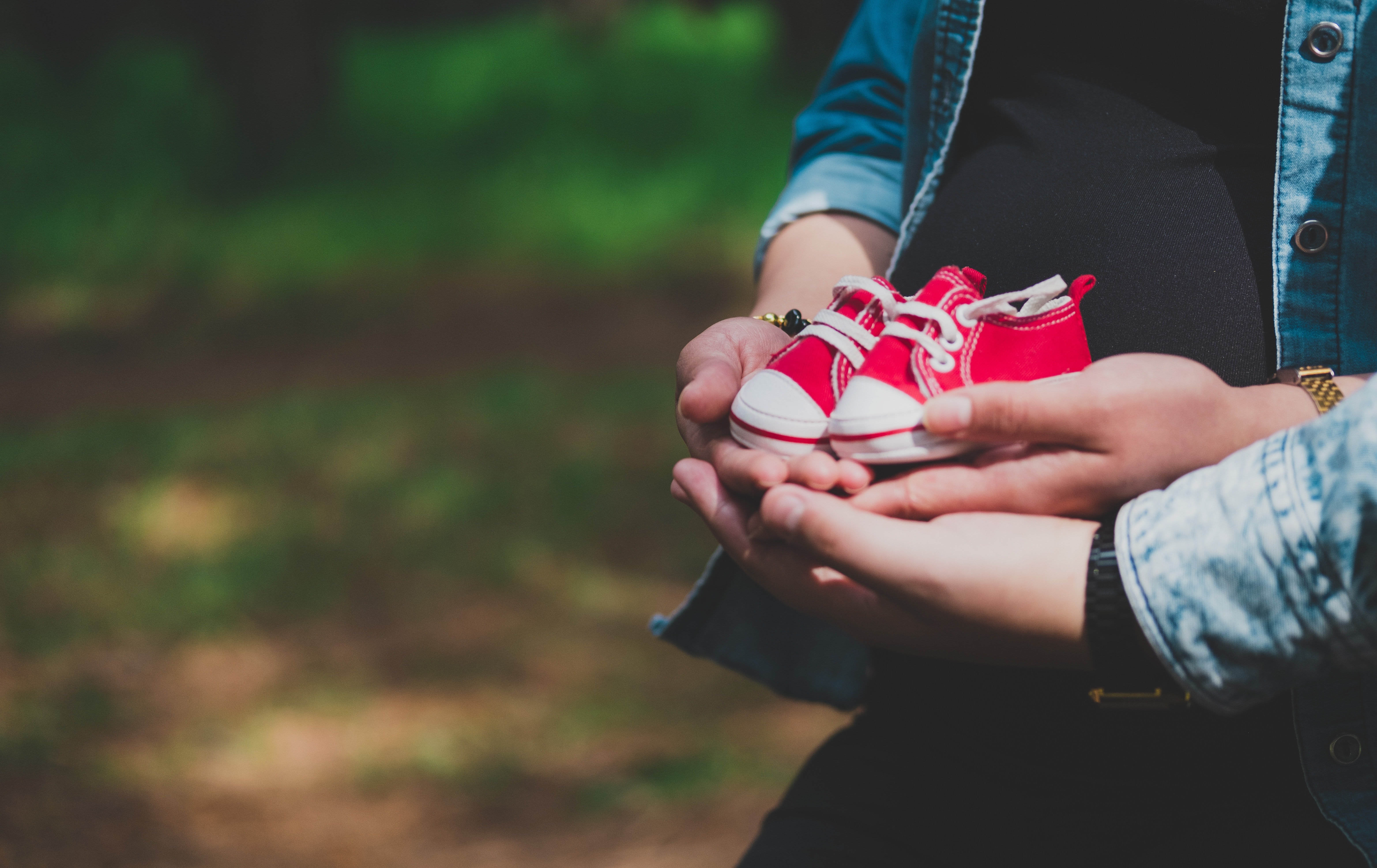 Couple hold a pair of tiny baby shoes | Photo: Unsplash/frankcreative360