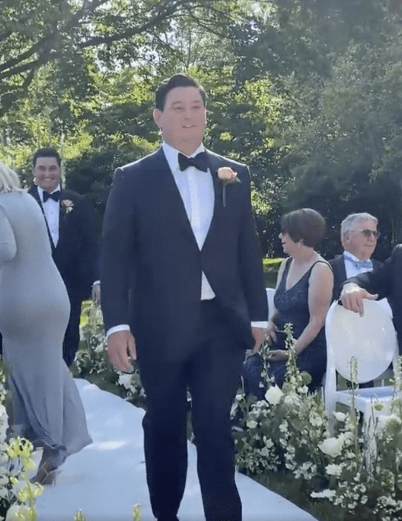 Der Bräutigam ist abgebildet, wie er den Gang hinuntergeht, während einer seiner Trauzeugen im Hintergrund lacht. | Quelle: reddit.com/r/weddingshaming