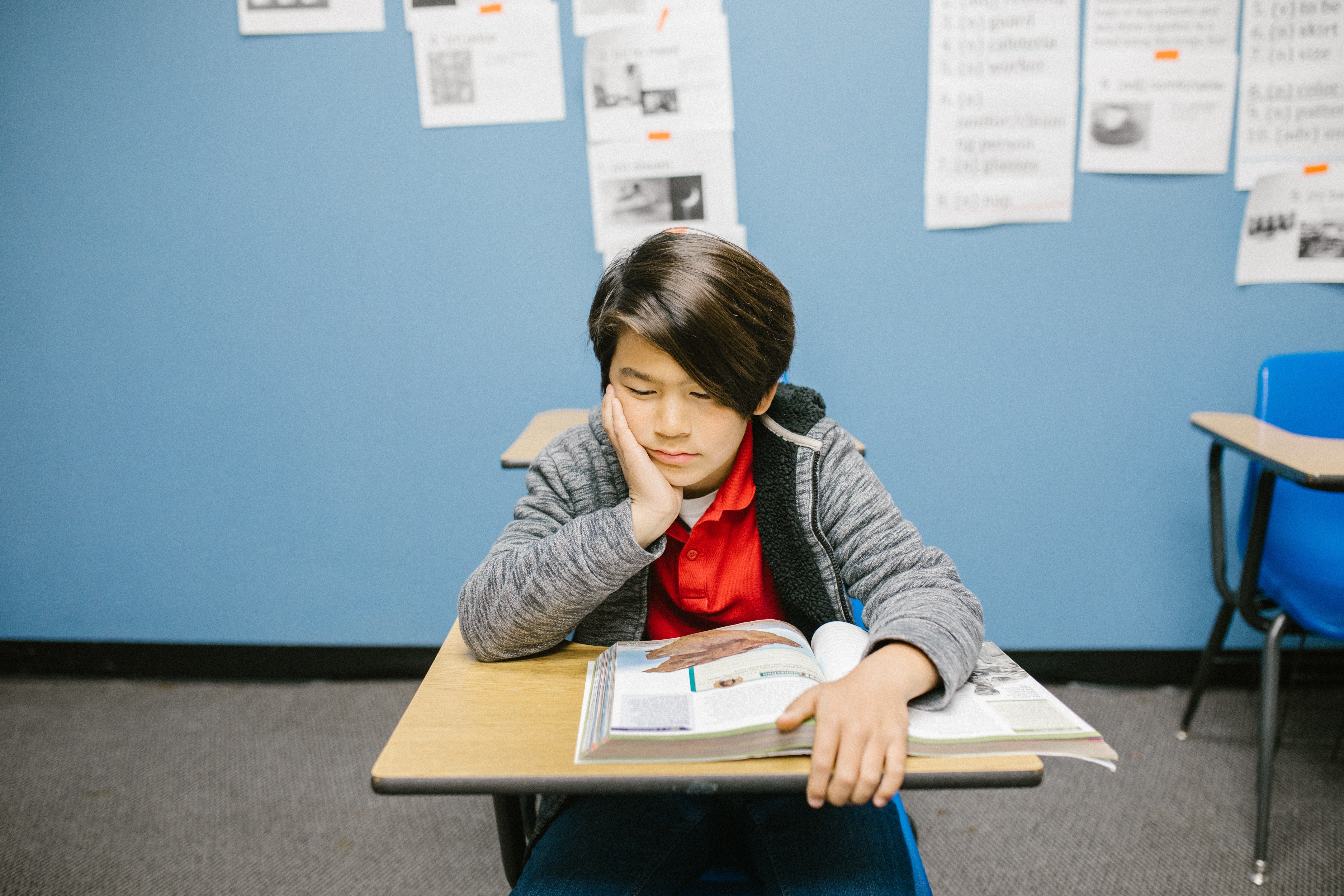 Un niño está sentado en su escritorio del aula escolar. | Foto: Pexels