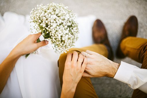 Bride and groom holding their hands together.| Photo: Getty Images.