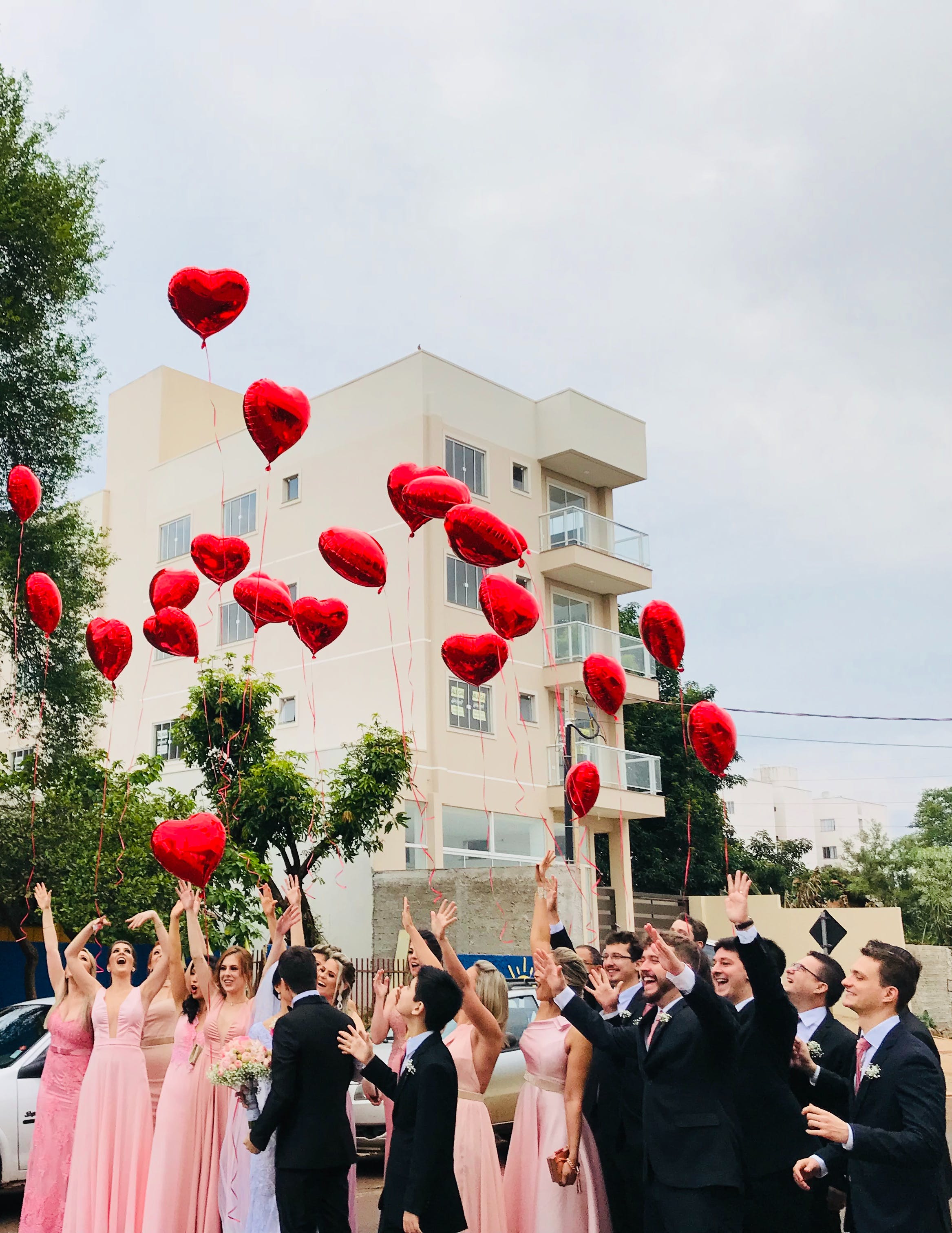 A wedding party releasing heart-shaped balloons in the street | Source: Pexels