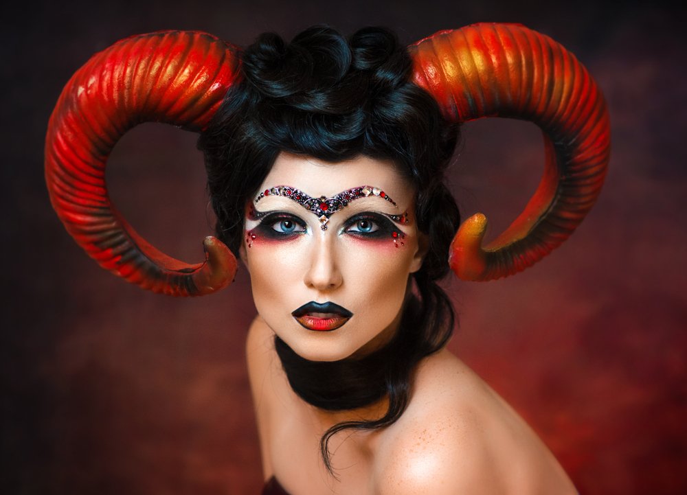 Chica sexy disfrazada del signo zodiacal Aries con cuernos en la cabeza. | Fuente: Shutterstock