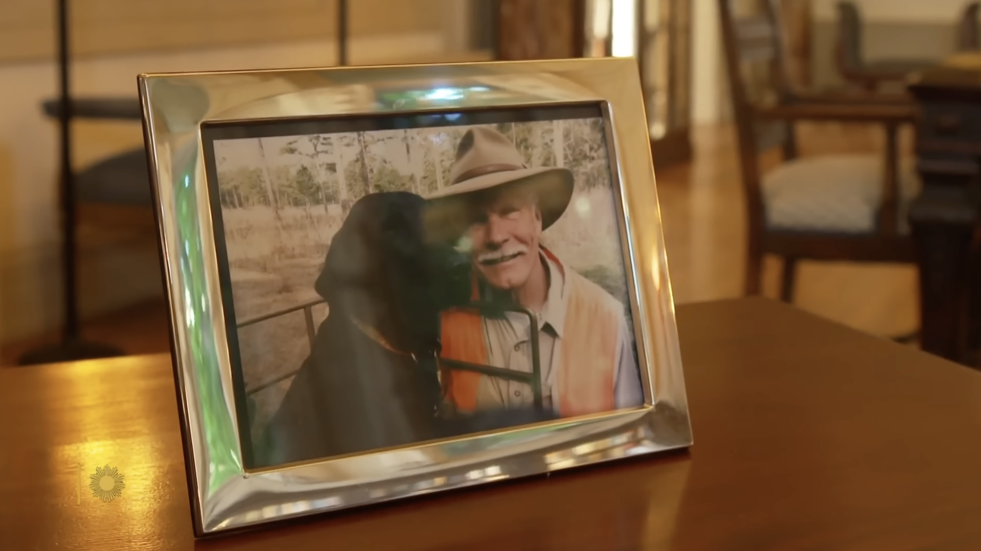 A framed portrait of Ted Turner wearing a cowboy hat sits displayed inside one of his rustic ranch homes. | Source: YouTube/CBS Sunday Morning