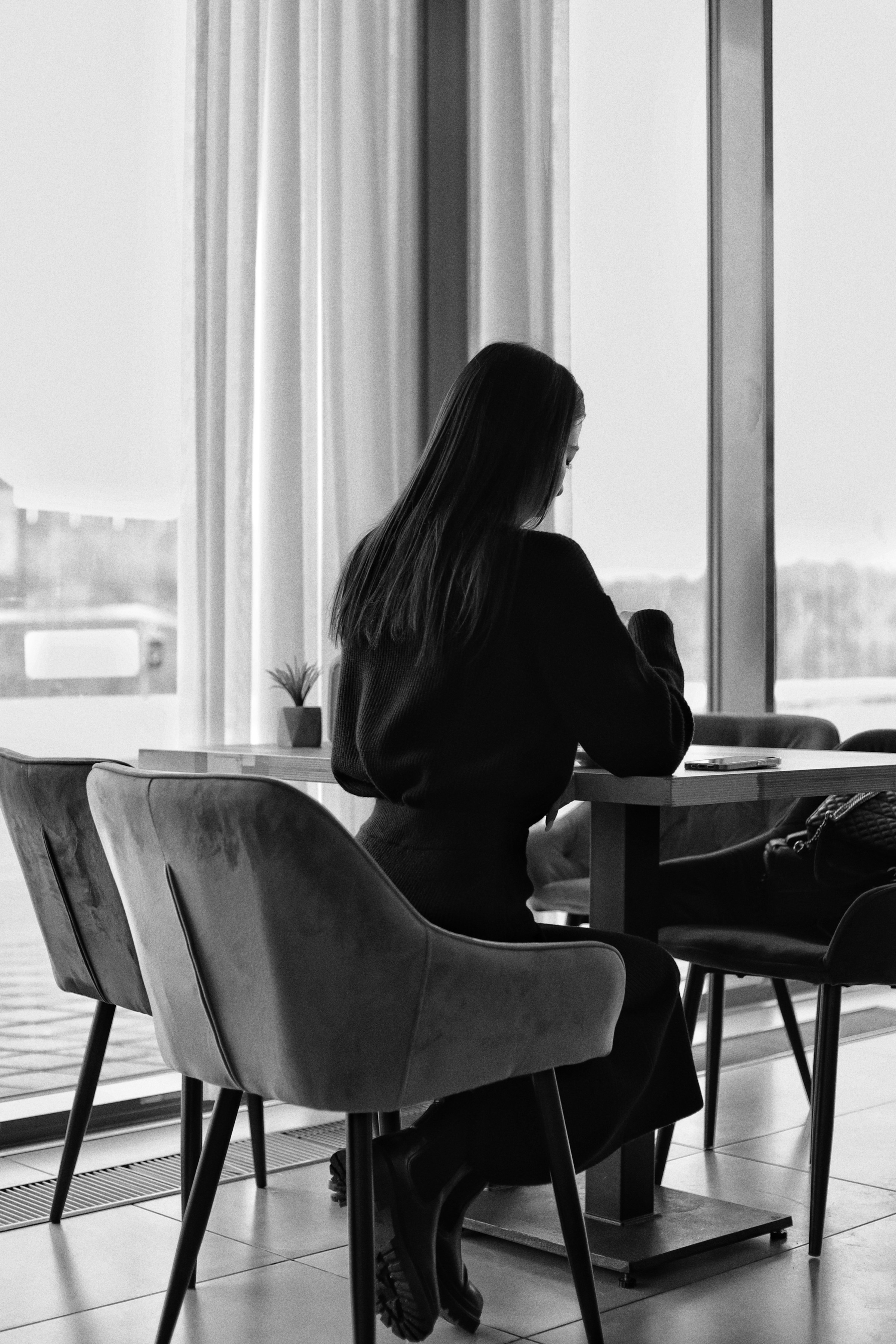 A woman sitting at a table in a restaurant in front of a window | Source: Unsplash