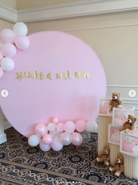 Pink decorations, balloons, and teddy bears are arranged around a "sprinkled with love" display | Source: Instagram/kieghan.nangle