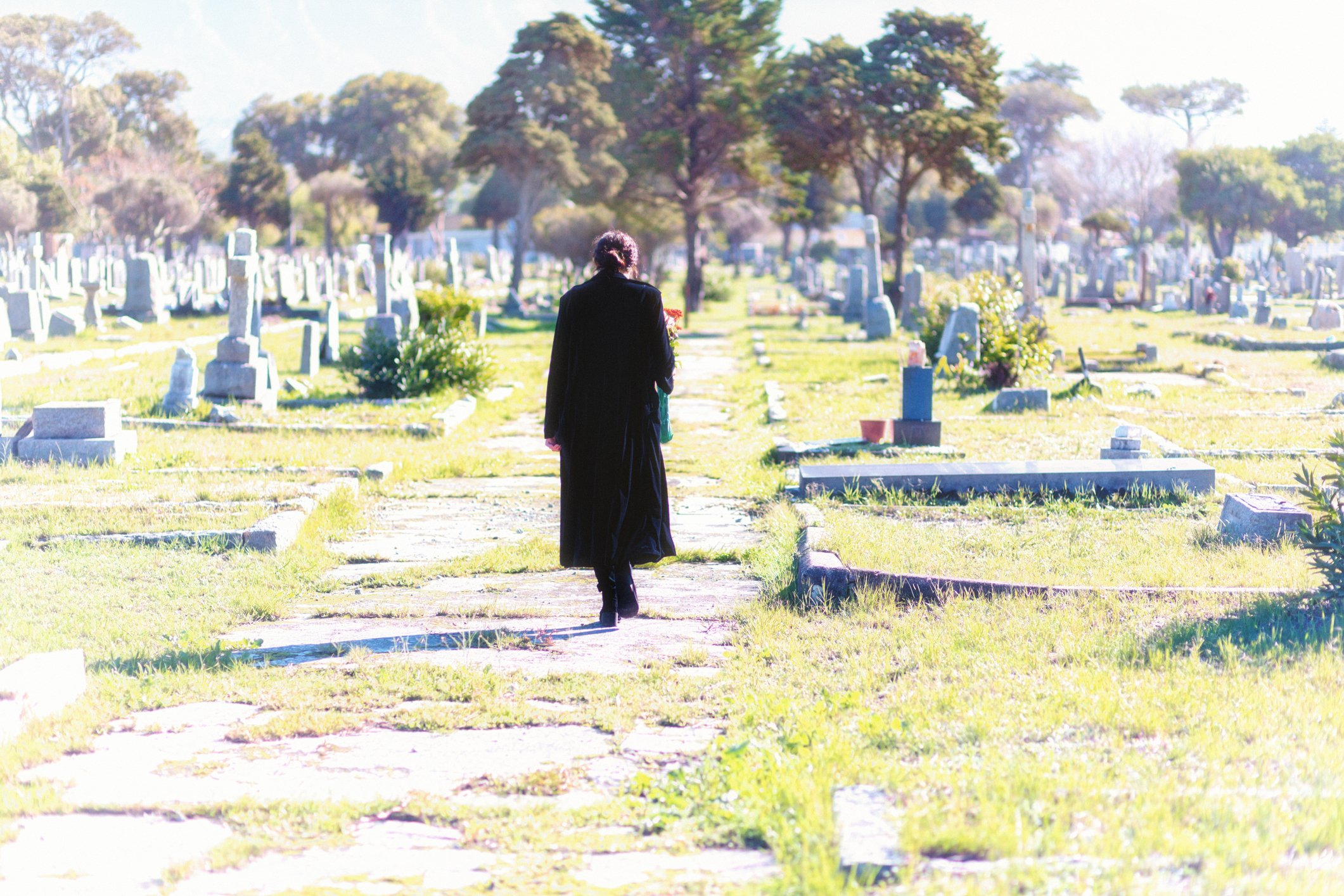 Mujer caminando por un camino de piedras en un cementerio. | Foto: Getty Images