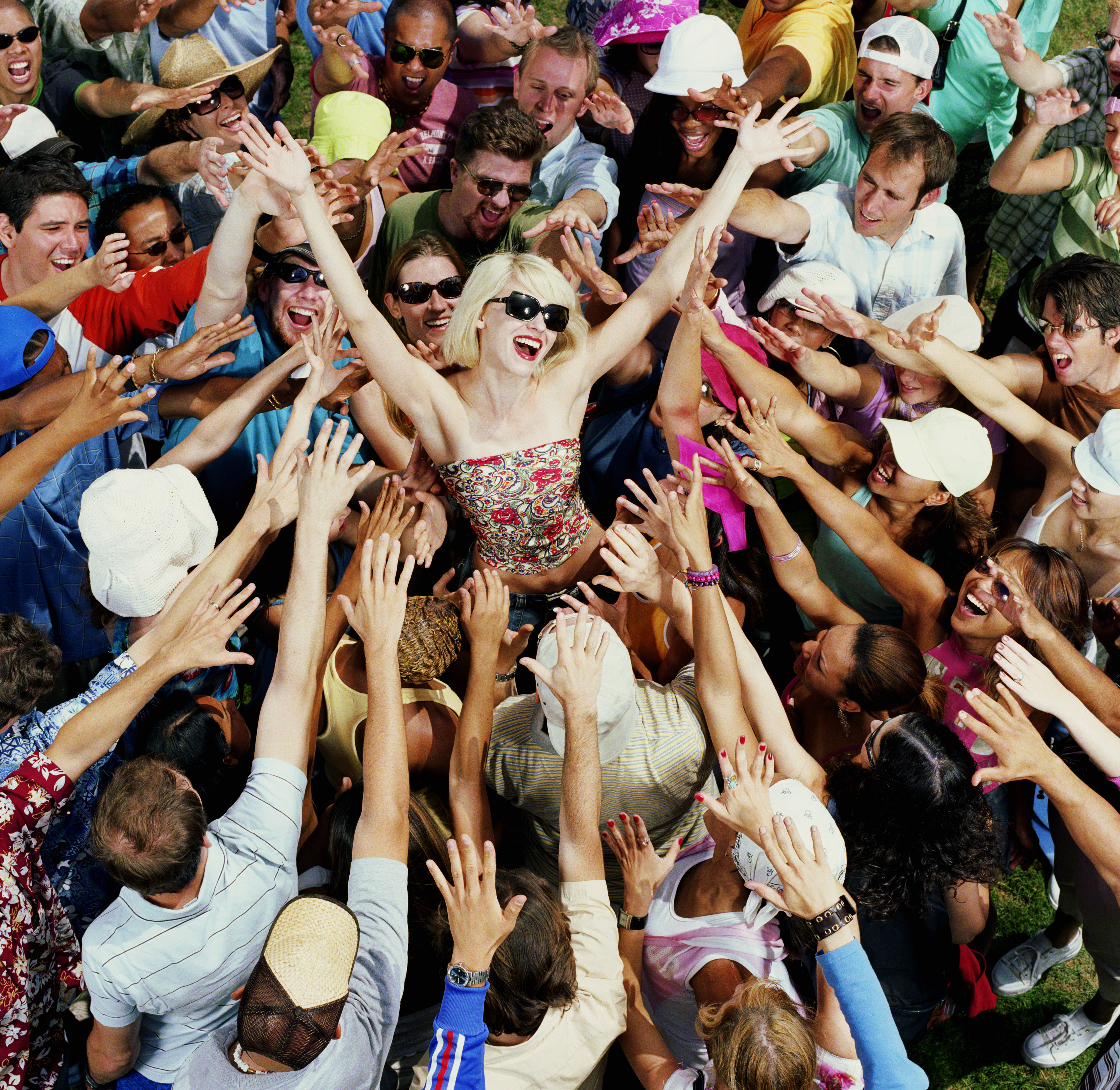 A woman smiling as she is the centre of attention in a crowd. | Source: Getty Images
