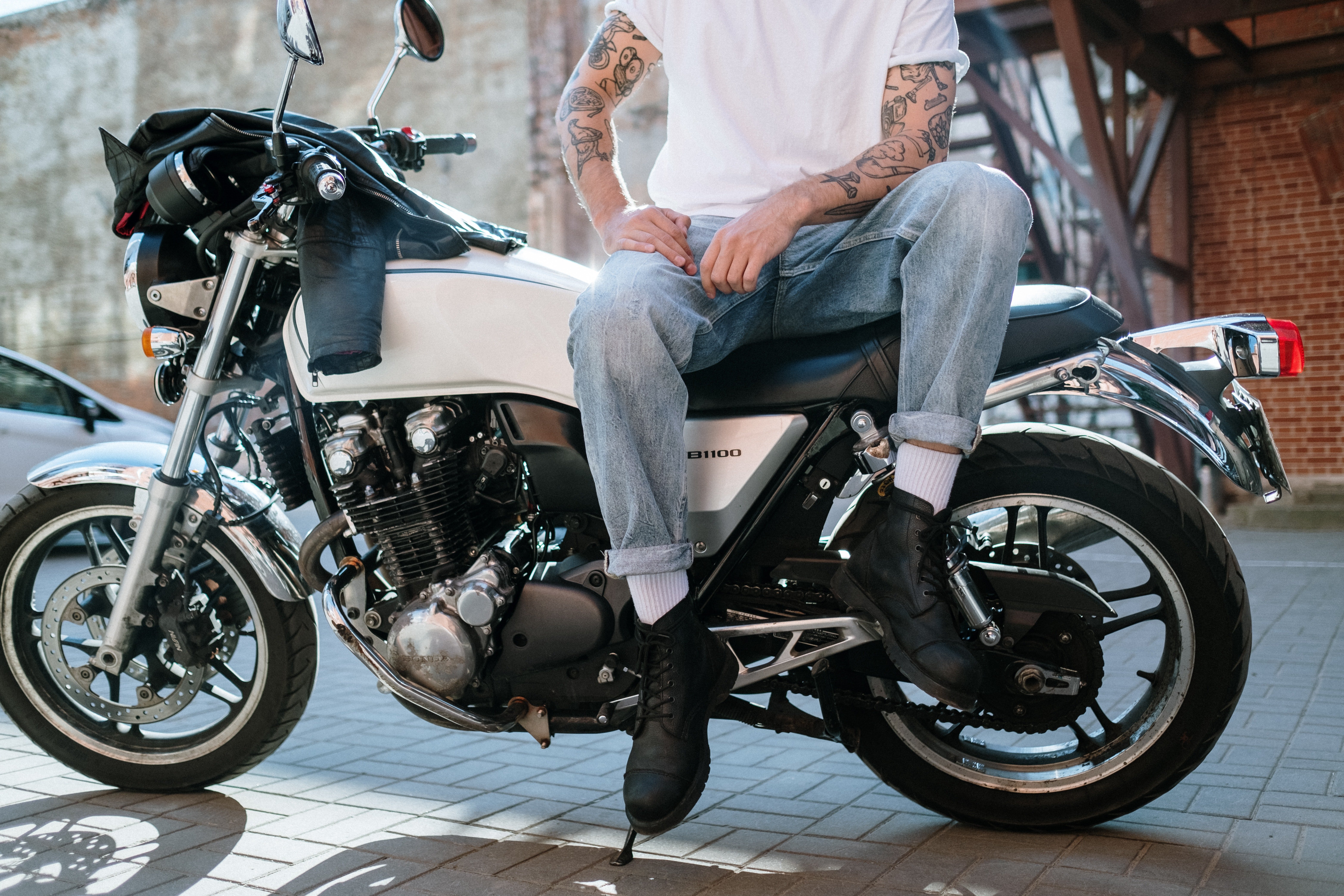 A man with tattoos sitting on a motobike. | Pexels/ cottonbro