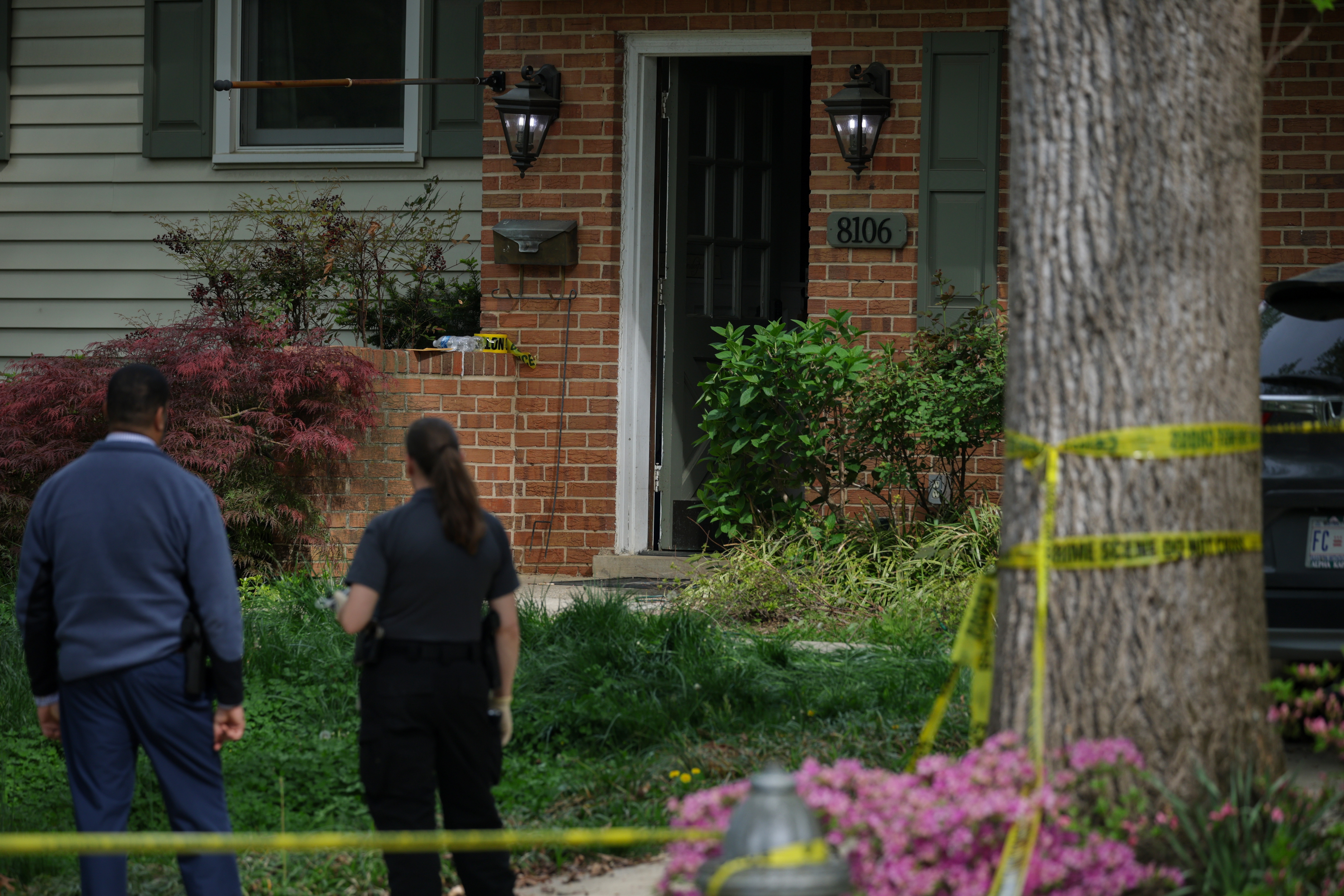 Two investigators approach the front door of the Fairfax home as crime scene tape surrounds the yard in Annandale, Virginia on April 16, 2026 | Source: Getty Images