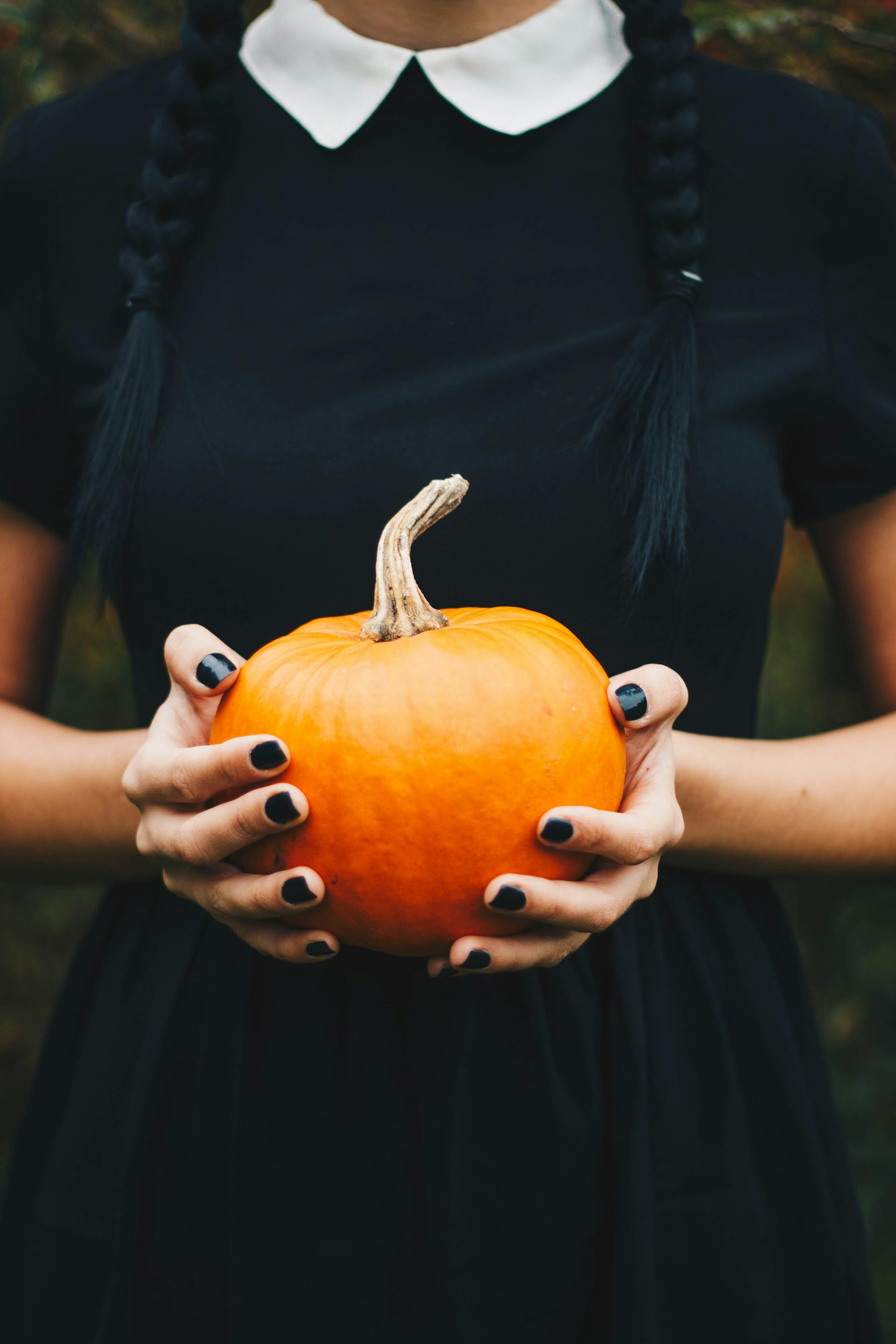 A closeup of a woman holding a pumpkin | Source: Pexels