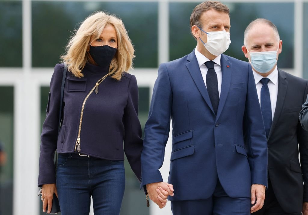 Emmanuel Macron et son épouse Brigitte Macron quittent un isoloir équipé de rideaux anti-covid avant de voter alors qu'ils votent dans un bureau de vote du Touquet le 27 juin 2021. | Photo : Getty Images