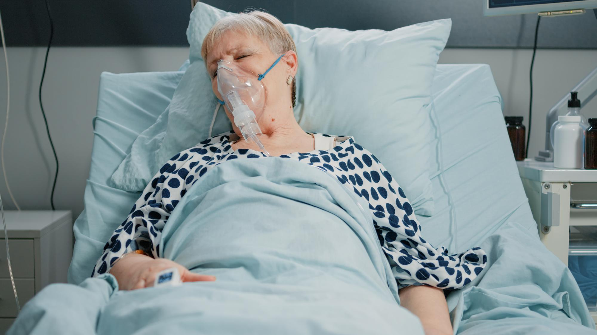 An ailing senior woman lying in a hospital bed | Source: Freepik