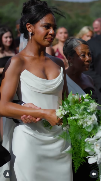 Britt Stewart walking down the aisle with her parents. | Source: Instagram/lightcannonfilms