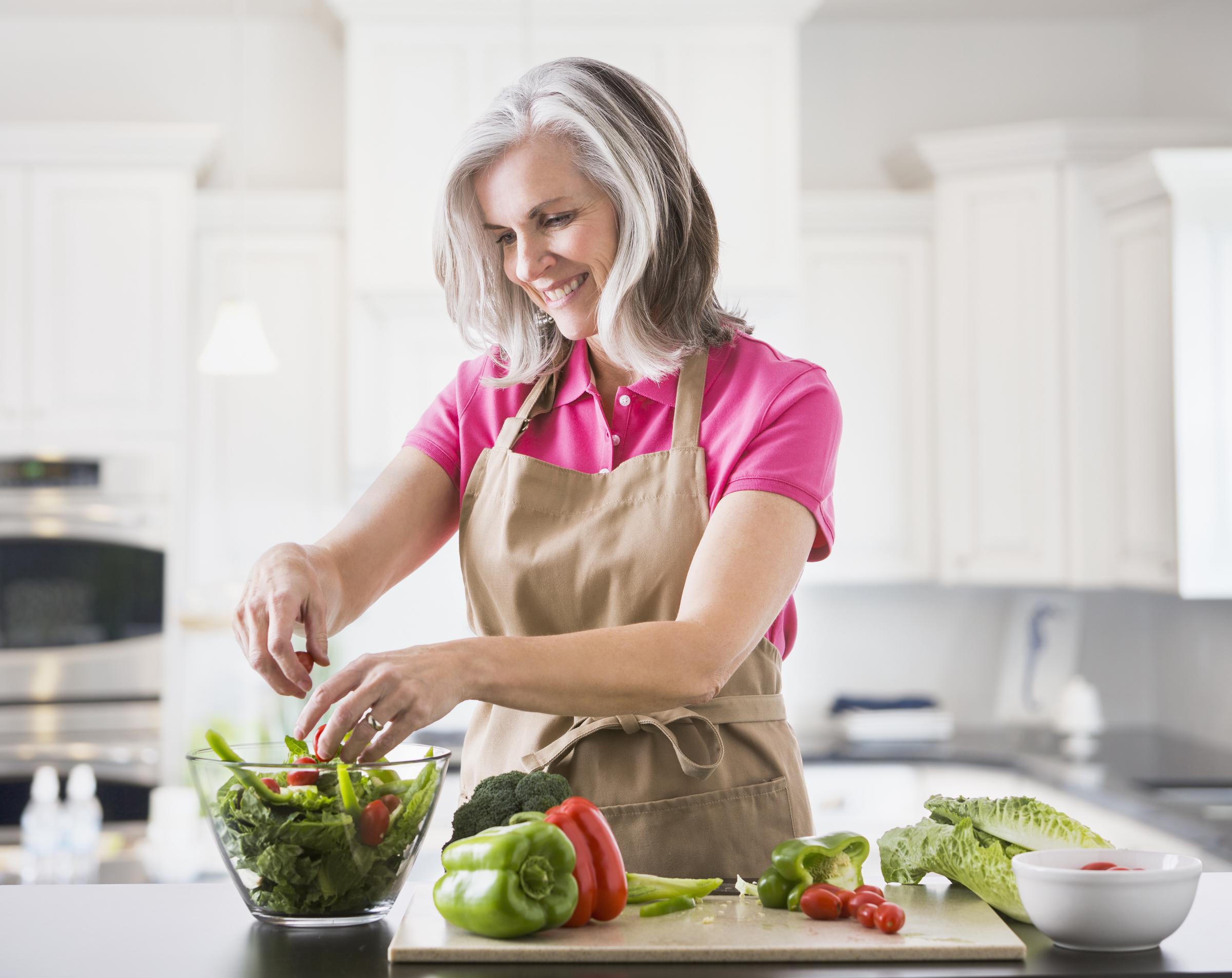 An older woman preparing a salad | Source: Getty Images