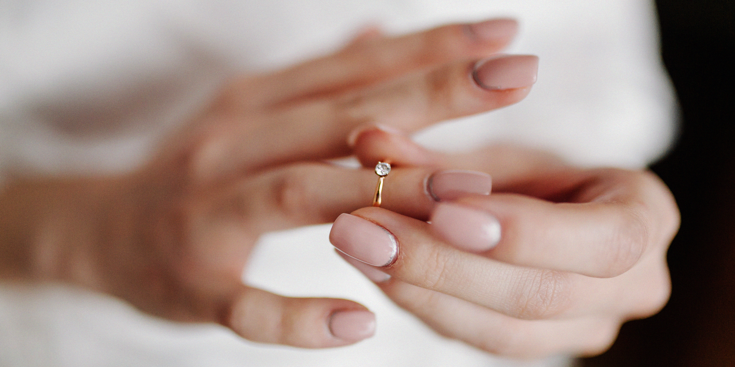 A woman holding an engagement ring through her finger | Source: Freepik