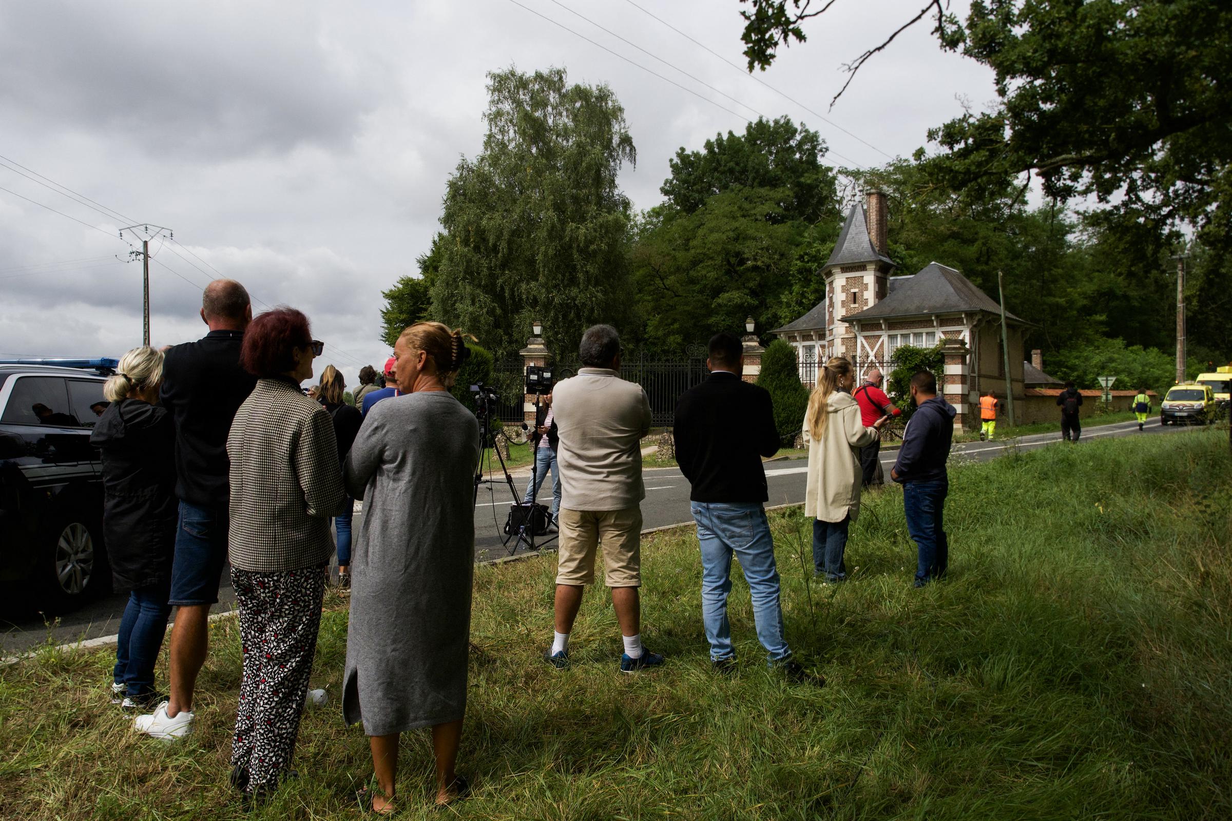 Inhabitants pay tribute as journalists work in front of the entrance of the property of Alain Delon, La Brulerie, in Douchy, central France, on August 18, 2024.