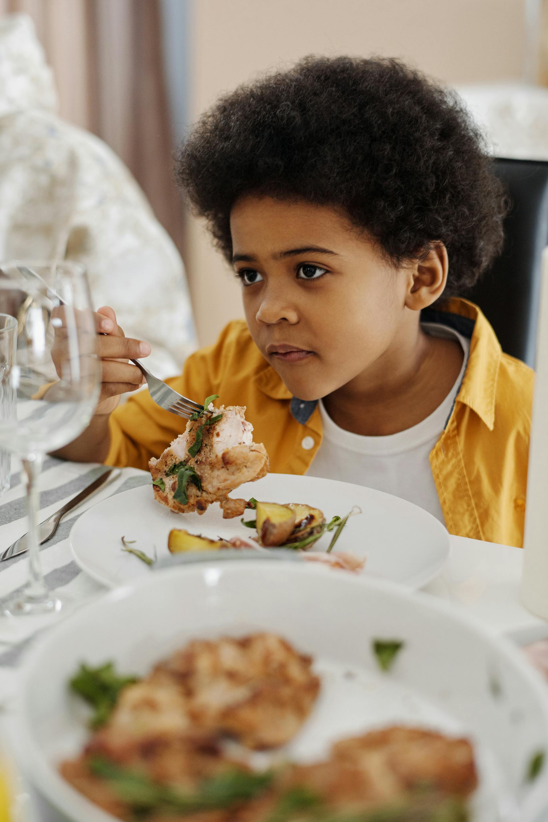 Boy at dinner looking confused | Source: Pexels