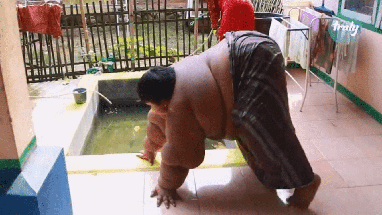 Arya Permana beside his bathing pond in his home | Photo: Youtube / Barcroft Tv
