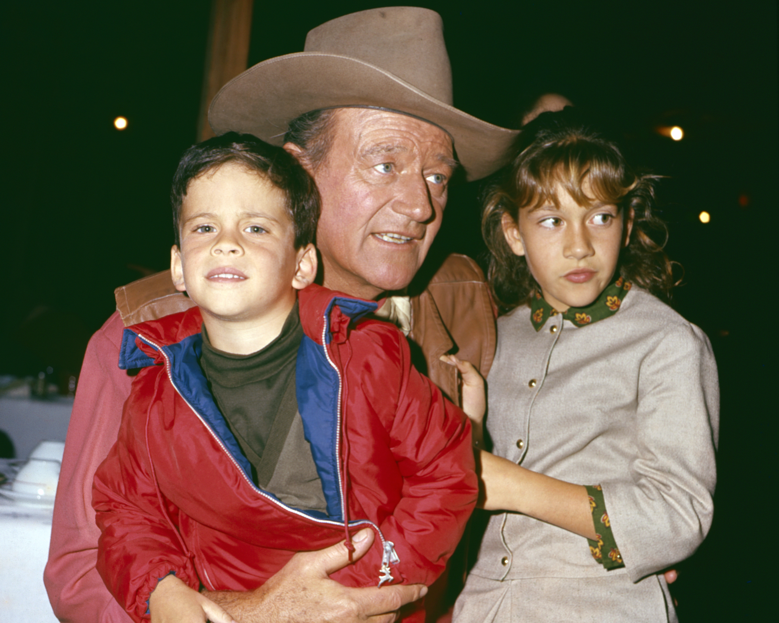 John Ethan Wayne, John Wayne as Cole Thornton for his role in "El Dorado," and Aissa Wayne photographed in a restaurant in 1967 | Source: Getty Images