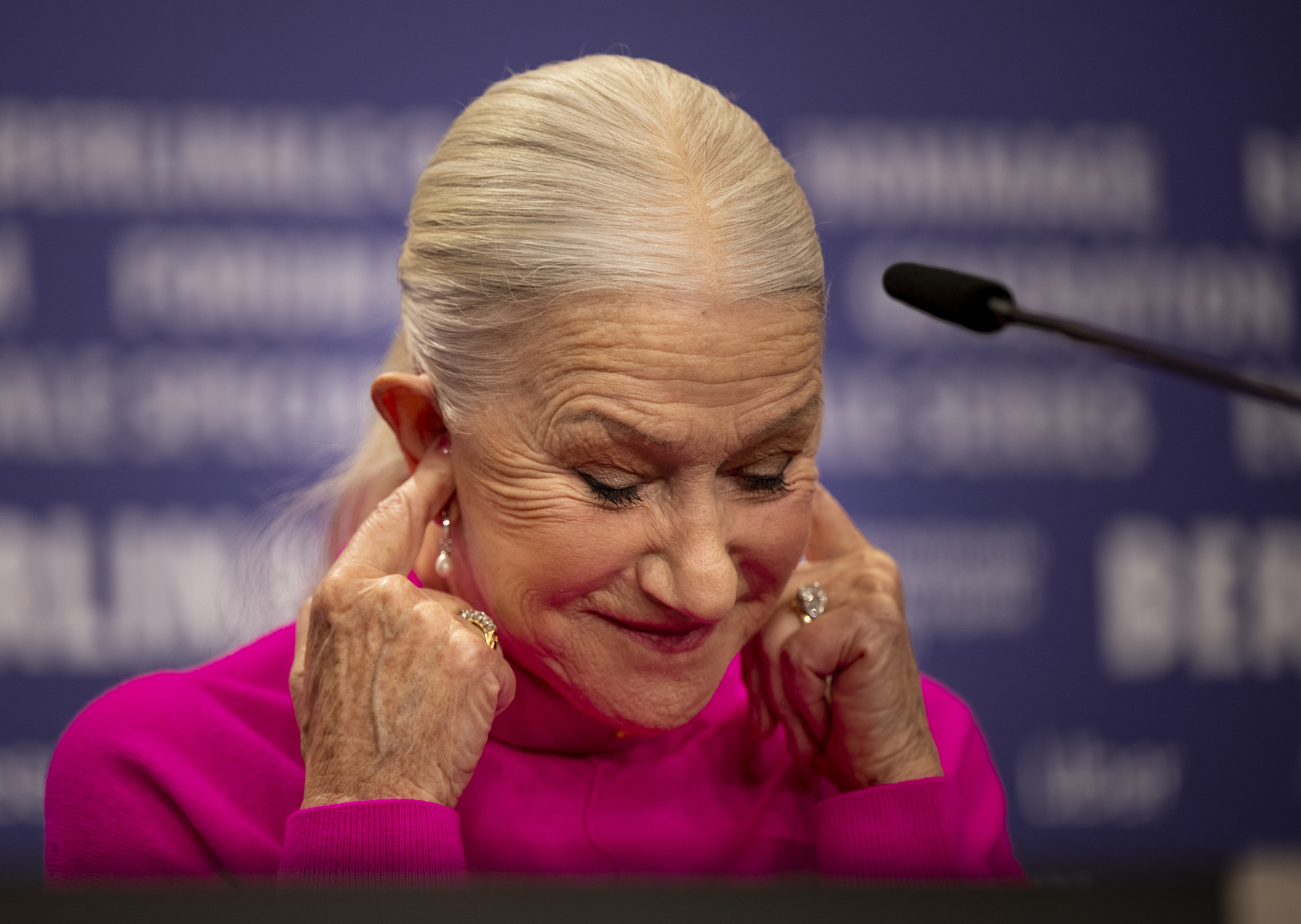 Helen Mirren covers her ears at the press conference for the film "Golda". The film is screening in the Berlinale Special Gala section, 2023. | Source: Getty Images
