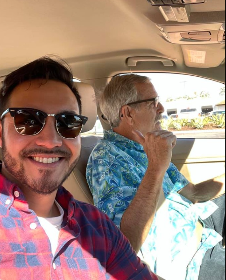 Michael Ryan Burke takes selfie as he rides in a car with another man,  from a post dated January 20, 2026. | Source: Facebook/MichelleMooreWinder