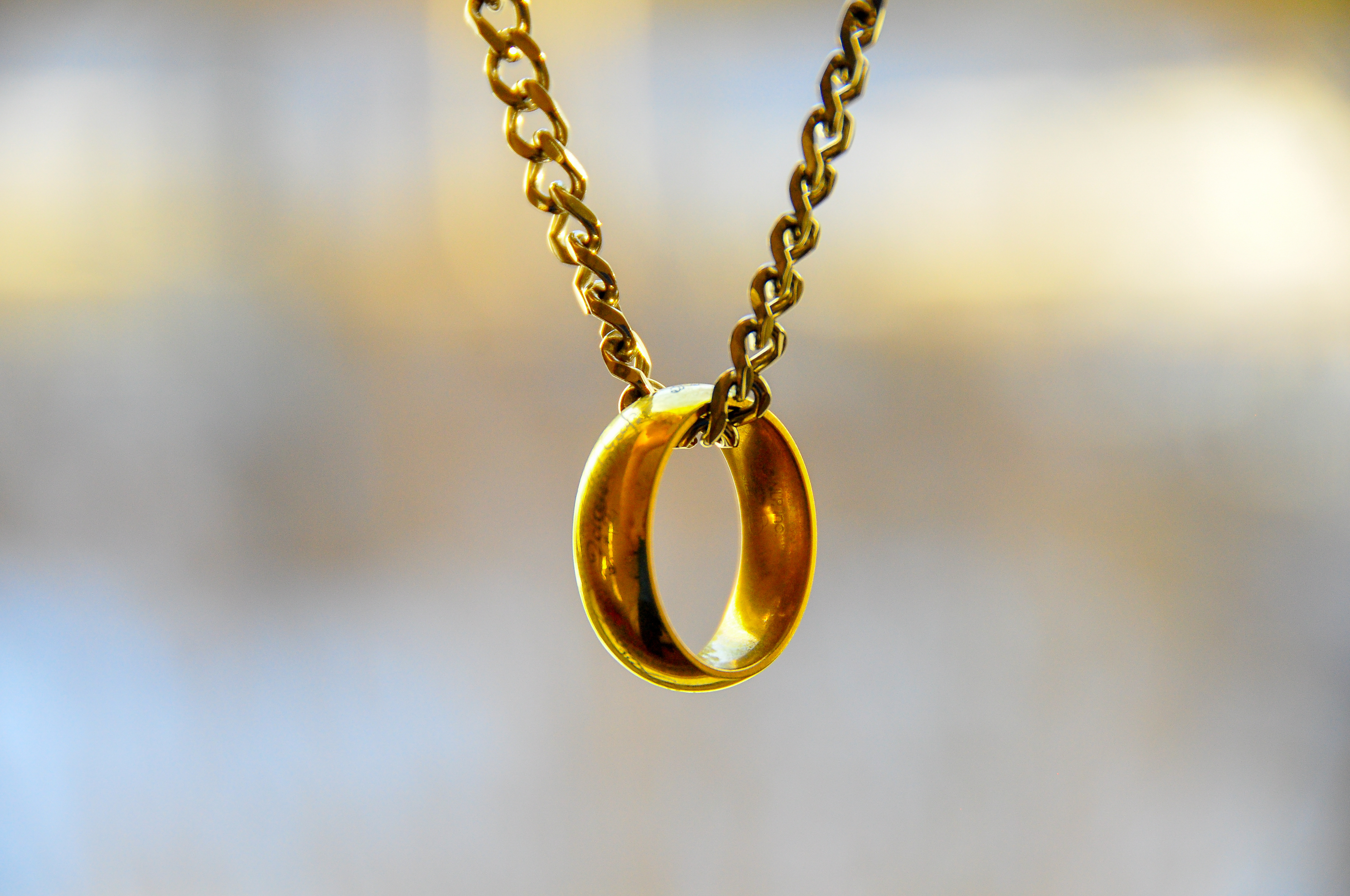A shiny golden ring on a matching chain | Source: Shutterstock