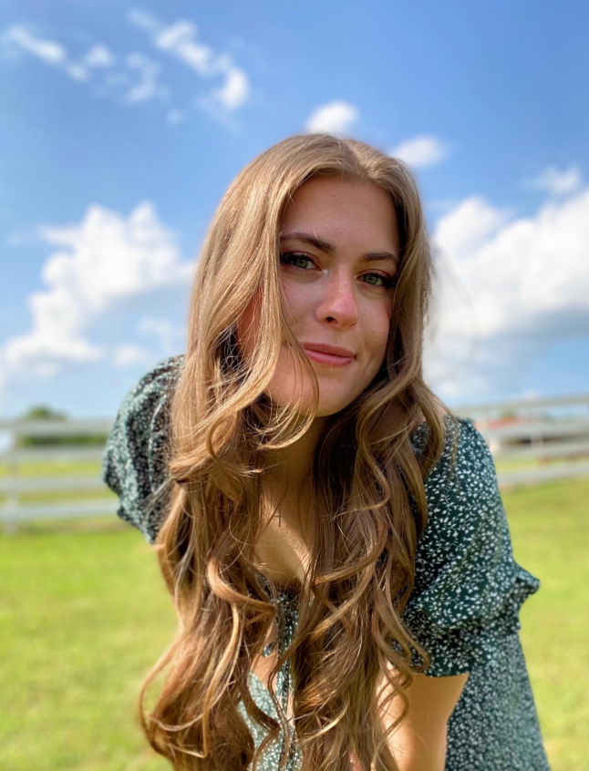 Danilee Norris leans into the sunlight, her soft smile and windswept hair capturing a carefree, natural glow against the open sky. | Source: Instagram/d.ani.lee