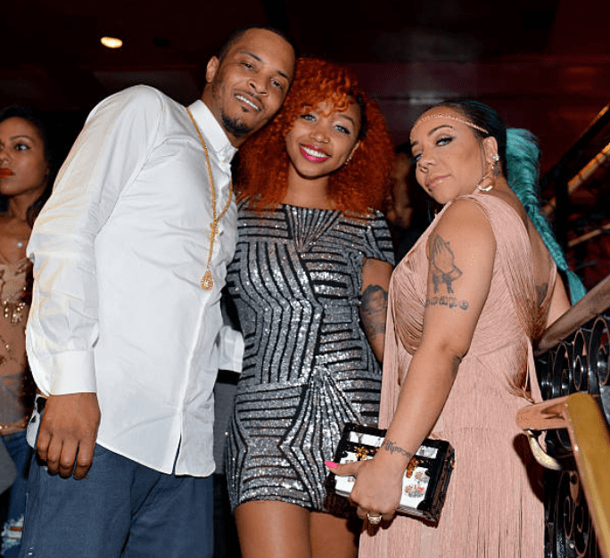 T.I., Zonnique Pullins, and Tameka "Tiny" Harris pose near the bar area at Tiny’s birthday party on July 14, 2015, in Atlanta, Georgia | Source: Getty Images