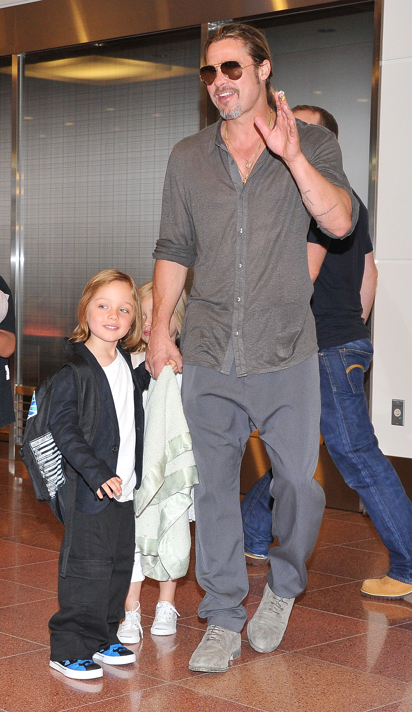Brad Pitt, Knox Jolie-Pitt, and Vivienne Jolie arrive at Tokyo International Airport on July 28, 2013, in Tokyo, Japan.
