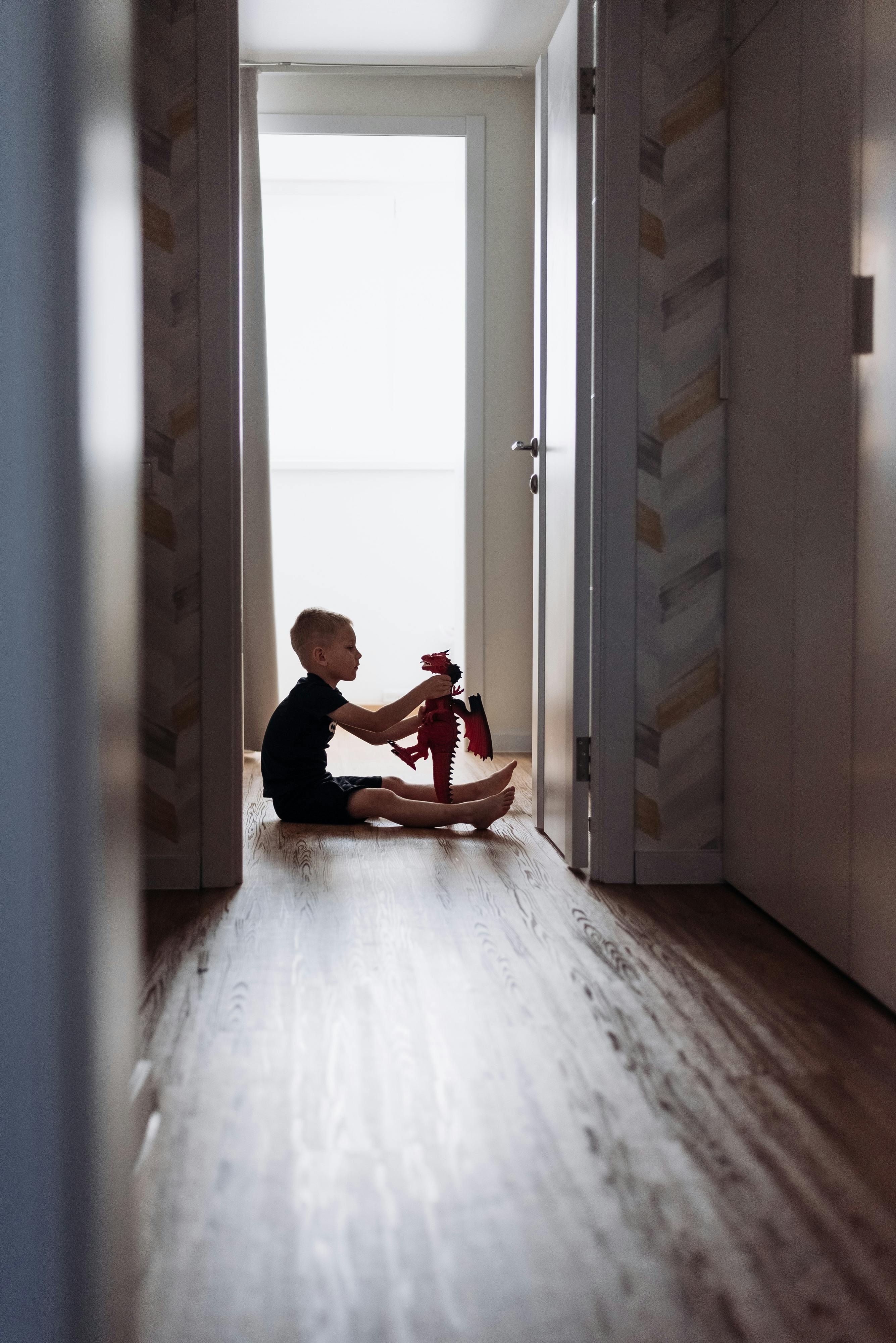 A child sitting on the floor playing with a toy | Source: Pexels
